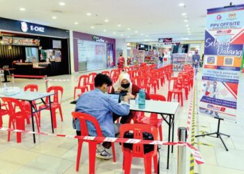 Seorang remaja mendaftar untuk mengambil vaksin penggalak Covid-19 secara walk-in di sebuah pasar raya di Kuantan,  Pahang, semalam. – UTUSAN/SHAIKH AHMAD RAZIF