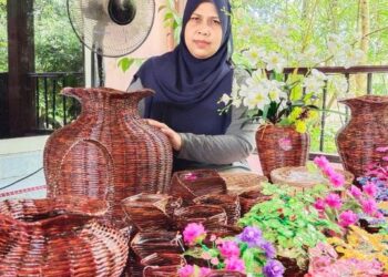 Asni Othman bergambar dengan sebahagian daripada produk kraf yang dihasilkannya dari rumah di Taman Tun Sardon, Bukit Mertajam baru-baru ini.