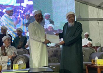 IDRIS Ahmad (kiri) menerima resolusi Ijtimak Pondok Se-Malaysia daripada wakil pondok, Wazir Che Awang di Pusat Pengajian Pondok Yayasan Islam Kelantan  Moden Kandis, Bachok, Kelantan. - UTUSAN/TOREK SULONG