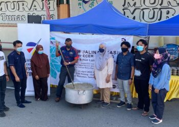 Yang Dipertua Majlis Daerah Mersing, Mohd. Norman Noh (tengah) mengacau bubur lambuk bersama peserta di program Jalinan Kasih empower ECER di Mersing.