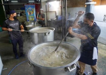 KAKITANGAN Masjid Saidina Hamzah, Kampung Batu Muda, Kuala Lumpur, memasak bubur lambuk untuk diedarkan secara percuma kepada orang ramai pada Program Kongsi Berkat Bubur Lambuk anjuran EB Frozen Food Sdn. Bhd. dan Media Mulia Sdn. Bhd. kelmarin. – UTUSAN/SHIDDIEQIIN ZON