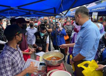 MUHAMAD AKMAL Saleh (kanan) ketika melakukan tinjauan di Bazar Ramadan Bandar Baru Merlimau, Jasin, Melaka. - UTUSAN/DIYANATUL ATIQAH ZAKARYA