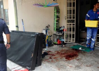 Seorang anggota polis melihat kesan darah  di ruang hadapan rumah dalam kejadian bunuh melibatkan ibu dan anaknya berusia dua bulan di Kampung Bakar Batu, Johor Bahru, semalam. – UTUSAN/RAJA JAAFAR ALI