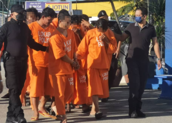 TERTUDUH, Tuan Mohamad Ridzwan Tuan Mohamad (dua dari kiri) diiringi oleh polis semasa hadir untuk perbicaraan di Mahkamah Majistret Pasir Puteh, Kelantan. - UTUSAN/ROSALWANI CHE SOH