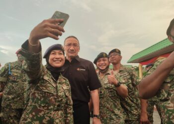 SEORANG anggota tentera mengambil kesempatan berswafoto bersama Hishammuddin Tun Hussein pada majlis berbuka puasa di Kem Lapangan Terbang, Sungai Petani, Kedah, semalam. - UTUSAN/NUR SYAZWANA MANSOR