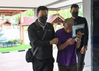 RADZALI Bahari (tengah) yang dituduh memberi rasuah kepada polis dibawa ke Mahkamah Sesyen Kuala Terengganu, hari ini. - UTUSAN/PUQTRA HAIRRY ROSLI