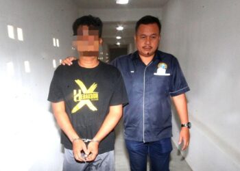 ANGGOTA polis mengiringi Amri Faisa Sauti (kiri) yang menghadapi pertuduhan cuba membunuh rakan sekampungnya di Mahkamah Sesyen Kota Bharu, Kelantan, hari ini. - UTUSAN/ZULHANIFA SIDEK