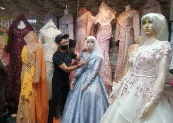 NIK Mat Ali Nik Chik membersihkan baju-baju pengantin di butik miliknya, Gila-Gila Pengantin di Kuala Berang, Hulu Terengganu. -UTUSAN/NOOR HAYATI MAMAT