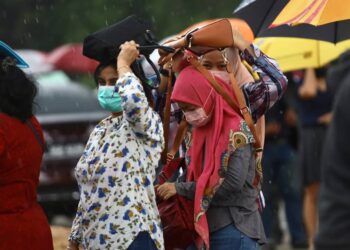 TIDAK kisah berhujan, mangsa banjir yang merupakan pemohon bantuan BWI dan BSB sanggup menunggu di luar Dewan MBSA Kemuning Utama bagi menerimanya di Shah Alam, Selangor hari ini. - UTUSAN / ZULFADHLI ZAKI