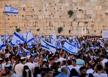 PENDUDUK Yahudi yang membawa bendera Israel berkumpul di hadapan Tembok Barat di kota lama Baitulmuqaddis. - AFP
