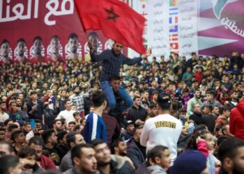 PEMINAT bola sepak mengibarkan bendera Maghribi ketika meraikan kemenangan negara itu melangkah ke separuh akhir Piala Dunia di Semenanjung Gaza, Palestin. - AFP