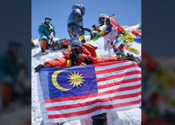 RAVICHANDRAN Tharumalingam mengibarkan Jalur Gemilang sebaik sahaja menjejak di puncak Gunung K2, Pakistan pada Jumaat lalu.