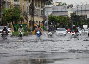 PENUNGGANG motosikal meredah banjir di jalan Tri Petch selepas dinaiki air di Bangkok. -BANGKOKPOST