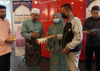 IDRIS Ahmad (dua dari kiri) menyampaikan sumbangan pada Program Hari Raya Asnaf di Taiping hari ini. - UTUSAN/WAT KAMAL ABAS