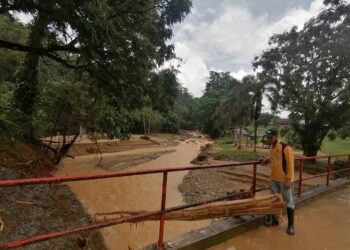 MOHD. Amran Awang meninjau kesan kerosakan di Taman Pertanian Negeri di Sekayu akibat banjir besar melanda daerah Hulu Terengganu. - NOOR HAYATI MAMAT
