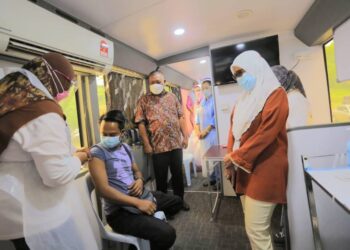 MOHD. Nizar Zakaria (tengah) melihat penerima disuntik vaksin pada program Belanja Outreach Vaksin Covid-19 di MRSM Parit hari ini. - UTUSAN/MOHAMAD HAFIZI MOHD. SAID