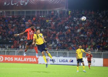 ISMAHEEL Akinade (kiri) melompat tinggi untuk menjaringkan gol pertama Kelantan FC menerusi tandukan pada aksi menentang Penang FC di Stadium Sultan Muhammad IV, Kota Bharu.-FOTO/KAMARUL BISMI KAMARUZAMAN