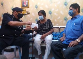 MIOR Faridalatrash Wahid (kiri) menyerahkan sumbangan kepada R. Letchumi di Lahat, Ipoh, hari ini. - FOTO/SAYED HESHAM IDRIS