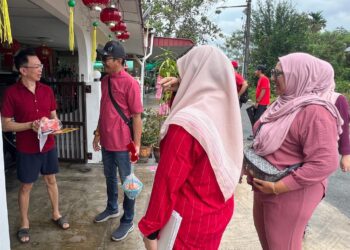 IZIZAM Ibrahim (dua dari kiri) beramah mesra dengan penduduk setempat sewaktu turun padang bagi beramah-mesra dengan masyarakat Tionghoa menjelang perayaan Tahun Baharu Cina di Padang Besar Perlis hari ini. -UTUSAN/ASYRAF MUHAMMAD