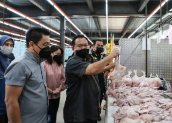 Menteri Perdagangan Dalam Negeri dan Hal Ehwal Pengguna, Alexander Nanta Linggi (kanan) memeriksa kualiti ayam dekat sebuah pasar raya di Seksyen 15, Shah Alam, Selangor hari ini. - UTUSAN / AFIQ RAZALI