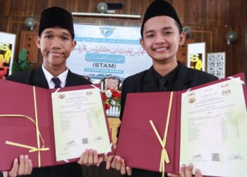 MUHAMMAD Zaurein (kiri) dan Muhammad Shahrul menunjukkan keputusan STAM di SMAT Tengku Ampuan Rahimah, Kuala Langat, Selangor, semalam. - UTUSANAN/AFIQ RAZALI