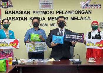 MUHAMMAD JAILANI Khamis (dua dari kanan) menunjukkan kit penjagaan kesihatan yang akaj diberikan kepada 1,000 pelancong terawal memasuki Melaka, Jumaat ini. - UTUSAN/DIYANATUL ATIQAH ZAKARYA