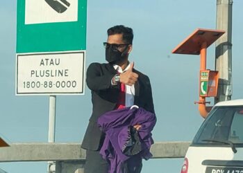 R. Kevin, 28, popular di media sosial hari ini selepas gambarnya yang sedang memegang jubah konvokesyen USM di atas Jambatan Pulau Pinang sambil mencuba nasib menahan penunggang motosikal yang sedang menghala masuk ke pulau tular.