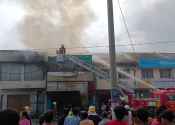 ANGGOTA bomba memadam kebakaran sebuah kedai di Jalan Besar Langkap, Teluk Intan, Perak, semalam. - IHSAN PDRM