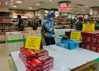 PELANGGAN memilih coklat Pepero yang dihadkan pembelian  dua kotak setiap pelanggan di Kompleks HIG, Kuah, Langkawi. - UTUSAN/NUR AMALINA AZMAN
