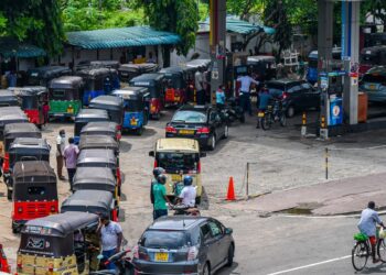 PEMANDU kereta beca beratur panjang bagi menunggu giliran mengisi minyak di stesen minyak di Colombo.-AFP