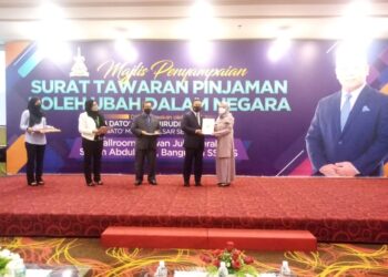 AMIRUDIN Shari  menyampaikan surat tawaran pinjaman kepada salah seorang penerima pinjaman di SUK Selangor, Shah Alam, Selangor hari ini. - UTUSAN/MOHAMAD NAUFAL MOHAMAD IDRIS