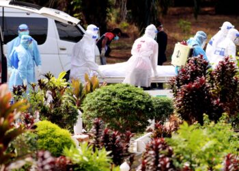 Kakitangan barisan hadapan 'Team Tok Adi' dari Pejabat Kesihatan Daerah Melaka Tengah dibantu Angkatan Pertahanan Awam Malaysia (APM) menguruskan jenazah pesakit covid-19 di Tanah Perkuburan Islam Kampung Tun Razak, Bukit Katil, Melaka hari ini. - UTUSAN/RASUL AZLI SAMAD