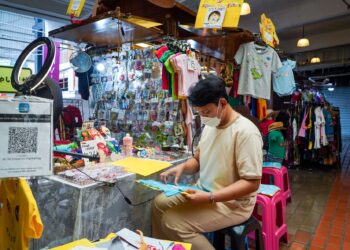 DANIEL Shah Mohd. Ridzwan, 31 sedang menyiapkan tempahan pelanggan di gerai menjual ‘personalized shirt’ miliknya yang kembali beroperasi selepas Kuala Lumpur berada di Fasa 2 Pelan Pemulihan Negara (PPN) dalam tinjauan di Pasar Seni, hari ini. - UTUSAN/MUHAMAD IQBAL ROSLI