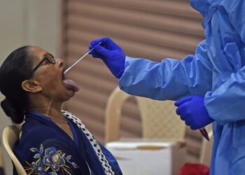 PETUGAS kesihatan mengambil sampel swab di Mumbai, India. - AFP