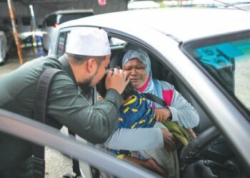 EBIT Lew mengucup dahi Nurainul Zahirah Rashidi selepas menghadiahkan Perodua Viva kepada ibu kanak-kanak OKU itu, Azimah Abd. Rahim, semalam. - FB EBIT LEW