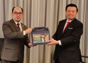 Taufik (kanan) menyampaikan cenderahati kepada Mohammad Shatar selepas majlis Bicara Eksekutif di Kota Kinabalu hari ini.