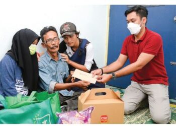 AZIZ Ahmad yang dalam kesedihan, ditenangkan oleh kedua anaknya, Nurul Adila Aziz
dan Ammar Haziq Aziz sewaktu menerima cek dari wakil MMBS Pulau Pinang, Mohd.
Syalmizi Hamid, baru-baru ini. – UTUSAN/IQBAL HAMDAN