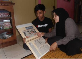 MOHAMMAD Nursyabil Syakirin Mohammad Nordin dan Norhayati Abu Bakar melihat keratan akhbar Utusan Malaysia mengenai laporan kes culik membabitkan dirinya ketika berusia enam hari di Sungai Lalang, Sungai Petani, Kedah.