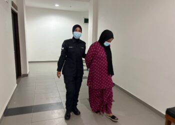 TERTUDUH (kanan) dibawa oleh anggota polis untuk pertuduhan di 
Mahkamah Majistret, Kota Bharu, Kelantan hari ini.