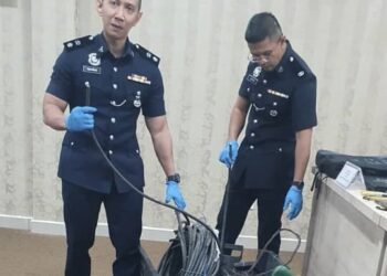 AHMAD Ridhwan Mohd. Nor (kiri) menunjukkan kabel tembaga yang dirampas daripada suspek di pejabatnya di IPD Kuala Langat, Selangor.