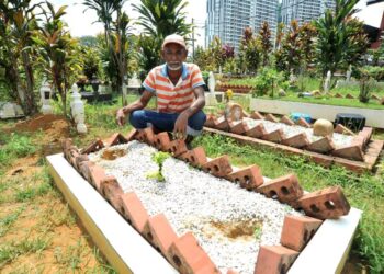 RAMLAN MOHAMMAD menunjukkan kehilangan dua batu nisan di salah sebuah kubur di Tanah Perkuburan Islam Taman Istimewa Pandan, Johor Bahru.