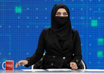 PENYAMPAI berita Tolo News, Thamina Usmani menutup wajahnya ketika bersiaran secara langsung di stesen televisyen di Kabul.-AFP