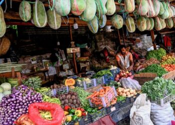 SEORANG peniaga menyusun barang jualan di gerainya di pasar di Colombo, Sri Lanka. - AFP