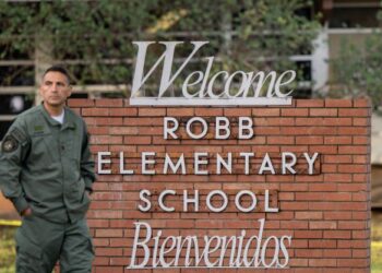 SEORANG pegawai polis berdiri di depan papan tanda Sekolah Rendah Robb di Uvalde, Texas. -AFP