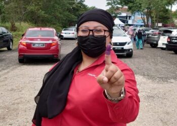 ERNALISA Othman menunjukkan jarinya yang diwarnakan sebagai tanda selesai membuang undi bagi kerusi DUN Johor Jaya, di Pasir Gudang, hari ini.
