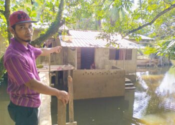 TUAN Syed Mohd,Saufi Tuan Soh menunjukan kawasan rumahnya masih digenangi banjir termenung di Kampung Tersang Rantau Panjang, Kelantan.UTUSAN/ROHANA ISMAIL