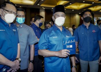 Tan Sri Muhyiddin Yassin menunjukkan dokumen Ikrar PN pada PRN  Melaka selepas majlis pelancarannya di Ballroom Glenmarie Hotel & Golf Resort di sini, hari ini. - UTUSAN / FARIZ RUSADIO