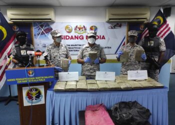 MOHD. ZAWAWI ABDULLAH (tengah) menunjukkan ketulan mampat dipercayai ganja yang cuba diseludup ke negara ini dalam sidang akhbar di Maritim Malaysia Zon Kuala Perlis hari ini.- UTUSAN/NAZLINA NADZARI