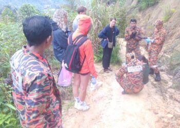 ANGGOTA bomba menemukan pendaki wanita yang cedera sebelum dibawa turun daripada Gunung Jasar, Cameron Highlands di Pahang hari. - FOTO/IHSAN JBPM Pahang