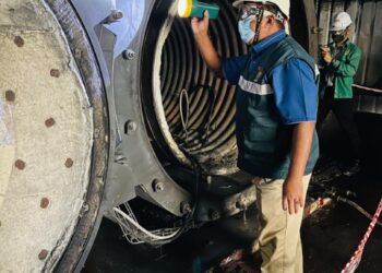 ZAMZURIN Maarof memeriksa pintu thermal oil heater yang meletup dalam kejadian di sebuah kilang pemprosesan batu kuari di Batu 3, Temoh di Tapah, Perak, semalam.